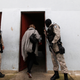 Guards escort Brazilian fashion designer Raquell Guimaraes into the Arisvaldo de Campos Pires maximum security penitentiary.